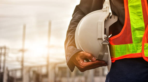 technician holding white hat safety hard hat sunlight background